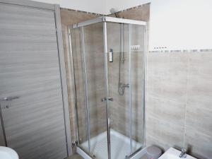 La salle de bains est pourvue d'une douche avec une porte en verre. dans l'établissement Casa Marinella, à San Giovanni Lupatoto