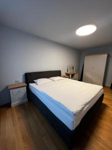 Un dormitorio con una gran cama blanca en una habitación. en Sunrise Lauku Apartments, en Liepāja