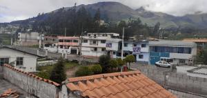 a city with buildings and a mountain in the background at Casa N Campestre en las faldas del Taita Imbabura in San Juan de Ilumán