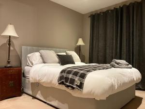 Un dormitorio con una cama con una manta. en Buckingham Court en Saint Albans