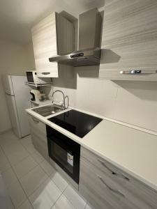 a kitchen with a sink and a refrigerator at Coin de la ville in Villeneuve