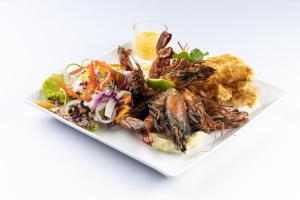 Maalu Maalu Resort & Spa - Thema Collection في باسيكودا: طبق من الطعام مع الكركند وسلطة