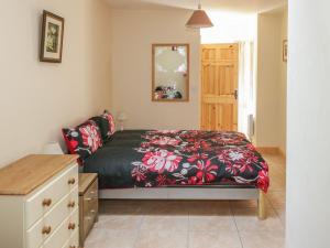 sypialnia z łóżkiem i komodą w obiekcie Glebe House w mieście Ballinrobe