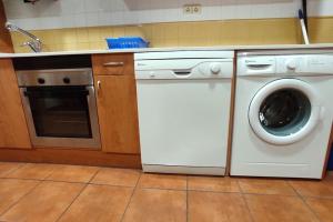 a kitchen with a washing machine and a dishwasher at Pirineos como en casa in Bielsa