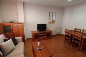 a living room with a couch and a tv on a table at Pirineos como en casa in Bielsa