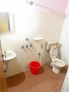 a bathroom with a toilet and a sink and a bucket at Homestay - Heaven Aumgarden in Trivandrum