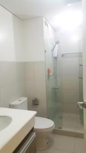 a bathroom with a toilet and a glass shower at The Levels 2BR Condo Fully Interior Cosmo Living in Manila