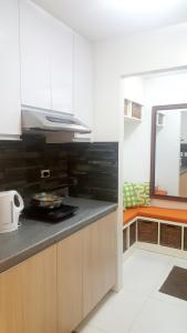 a kitchen with white cabinets and a stove top oven at The Levels 2BR Condo Fully Interior Cosmo Living in Manila