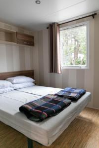 Un dormitorio con una cama con una manta. en Camping Tucan - Mobile Homes by Lifestyle Holidays, en Lloret de Mar