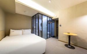 a bedroom with a white bed and a table at Hotel Daisy in Seoul