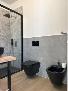 uma casa de banho com um WC preto e um chuveiro em Apartment Regina Luxury Lugano em Lugano
