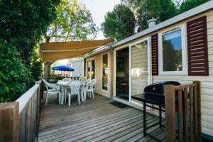 a deck with a table and chairs and an umbrella at Camping Tucan - Mobile Homes by Lifestyle Holidays in Lloret de Mar