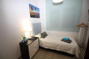 a small bedroom with a bed and a dresser at Nuevo Balmes Habitaciones in Barcelona