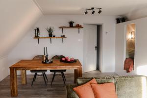 ein Esszimmer mit einem Tisch und einem Sofa in der Unterkunft Ruim en landelijk appartement in Wolphaartsdijk