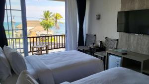 a hotel room with two beds and a view of the ocean at Adiwana Jelita Sejuba Natuna in Ranai