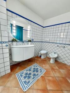 uma casa de banho com uma banheira, um WC e um espelho. em Jennas-Grecale Apartment em Arbatax