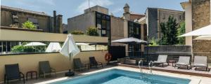 - une piscine avec des chaises et des parasols dans un bâtiment dans l'établissement Hôtel Oceania Le Métropole, à Montpellier