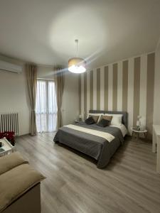 1 dormitorio con 1 cama grande y 1 sofá en Fior&Iris Apartments en Stresa
