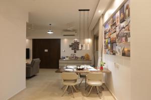 Artist House 3BR By Flora Stays في مومباي: مطبخ وغرفة طعام مع طاولة وكراسي