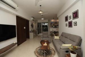 a living room with a couch and a tv at Artist House 3BR By Flora Stays in Mumbai