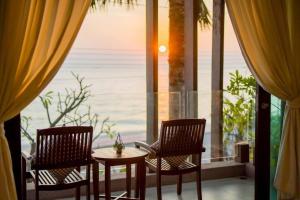 2 sillas y una mesa frente a una ventana en De' sea Stay PoolVilla @Pranburi ปราณบุรี, en Ban Pak Nam Pran