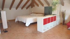 een slaapkamer met een bed en een tv op een dressoir bij Caffè del Viaggiatore in Valsolda