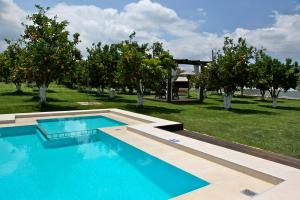 a swimming pool in the middle of a field with trees at Neriana Villa - Garden Paradise in Chania Town
