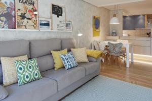 a living room with a gray couch with colorful pillows at ATeRIAN EUROMAR I in Zarautz
