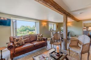 a living room with a brown couch and chairs at Broughwood Cottage Snowshill in Broadway