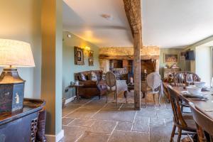 Broughwood Cottage Snowshill في برودواي: غرفة معيشة مع طاولة وكراسي