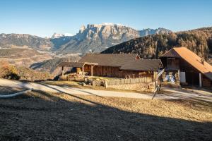 una casa en una colina con montañas en el fondo en Aschnerhof Holzherz en Collalbo