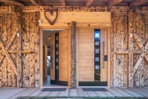 una puerta delantera de una casa de madera con un corazón en ella en Aschnerhof Holzherz en Collalbo