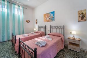 2 camas en una habitación con sábanas rosas en Casa Lamarmora, en Nebida