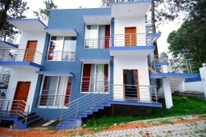 a blue and white house with stairs in front of it at GV Resort in Yercaud