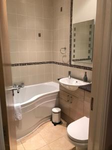 a bathroom with a tub and a sink and a toilet at Southover Beach in Woolacombe
