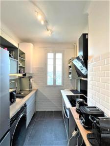 a white kitchen with a stove and a window at SUPERBE APPARTEMENT 2 PIECES A 200 METRES GARE in Melun