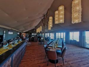 a restaurant with tables and chairs and a bar at TimBila Safari Lodge in Omaruru
