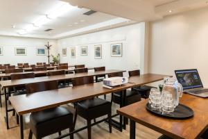 a classroom with tables and chairs and a laptop at Hotel Amado in Pori