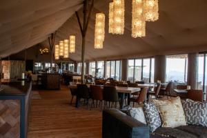 a dining room with tables and chairs and chandeliers at TimBila Safari Lodge in Omaruru