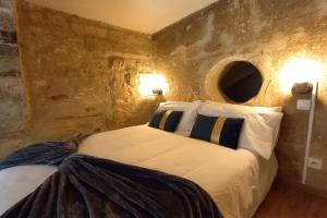 a bedroom with a bed in a stone wall at Ambre...La perle rare in Montpellier