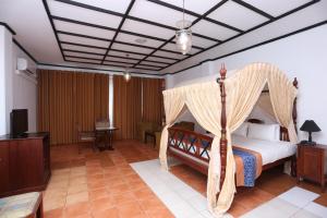 een slaapkamer met een hemelbed bij Grand Oriental Hotel in Colombo