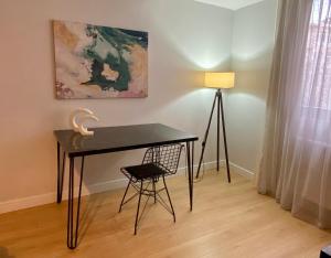 einen Schreibtisch mit einem Stuhl und einer Lampe in einem Zimmer in der Unterkunft New Apartment by MSuites in Kadikoy 01 in Istanbul