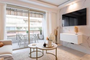 salon z kanapą i telewizorem na ścianie w obiekcie Magnifique Appartement 5 stars - Parking - Terrasse - 3 Mins De La Croisette - Palais Royal by Halldis w Cannes