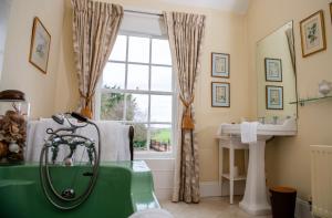 a bathroom with a tub and a sink and a window at Ballymote Country House in Downpatrick