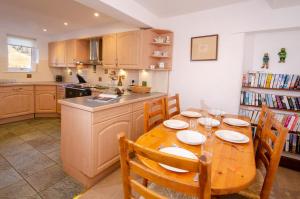 a kitchen with a wooden table with chairs and a dining room at Bens Cottage in Chapel Stile