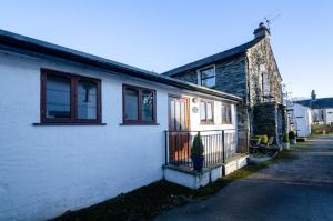 a white house with a potted plant in front of it at Bens Cottage in Chapel Stile