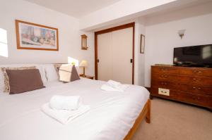 a bedroom with a bed with a television and a dresser at Bens Cottage in Chapel Stile