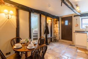 cocina y comedor con mesa y sillas en Stunning 2 Bed Cotswold Cottage Winchcombe, en Winchcombe