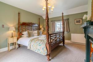 a bedroom with a four poster bed and a fireplace at Stunning 2 Bed Cotswold Cottage Winchcombe in Winchcombe