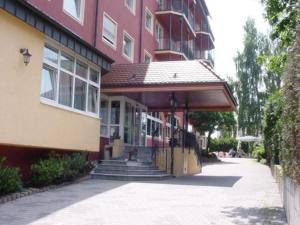 a large red building with a porch on a street at Abakus-Hotel in Sindelfingen